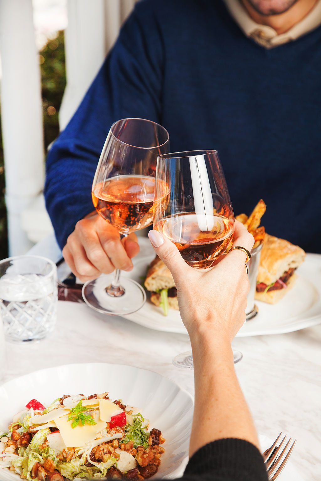 Two guests toasting glasses of ros&eacute; over lunch, part of the Savor & Stay package